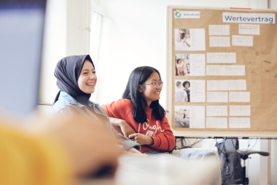 Zwei Mädchen sitzen in einem Klassenzimmer bei einem worldlab Workshop.